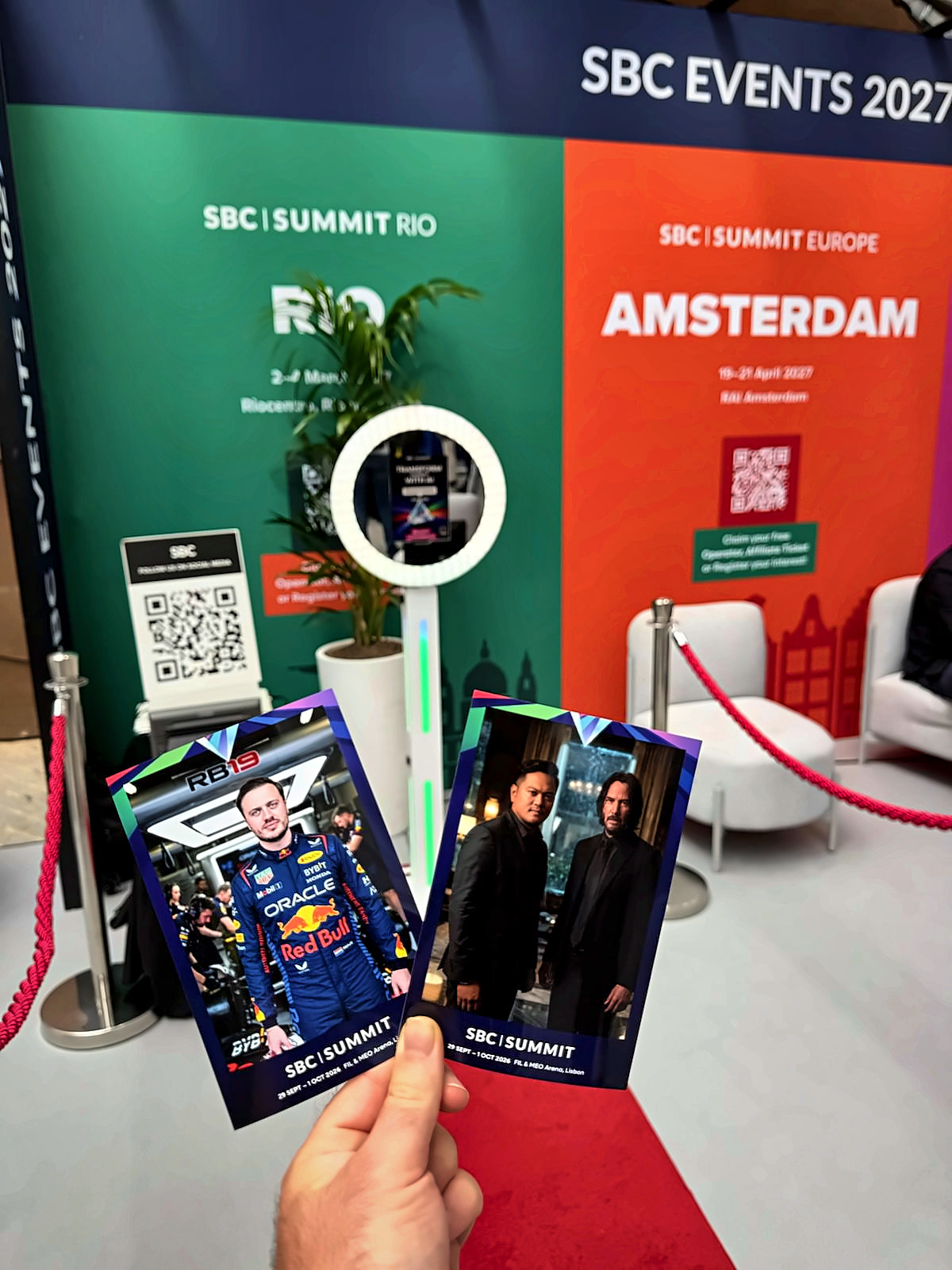 Hand holding two AI photo prints at a trade show