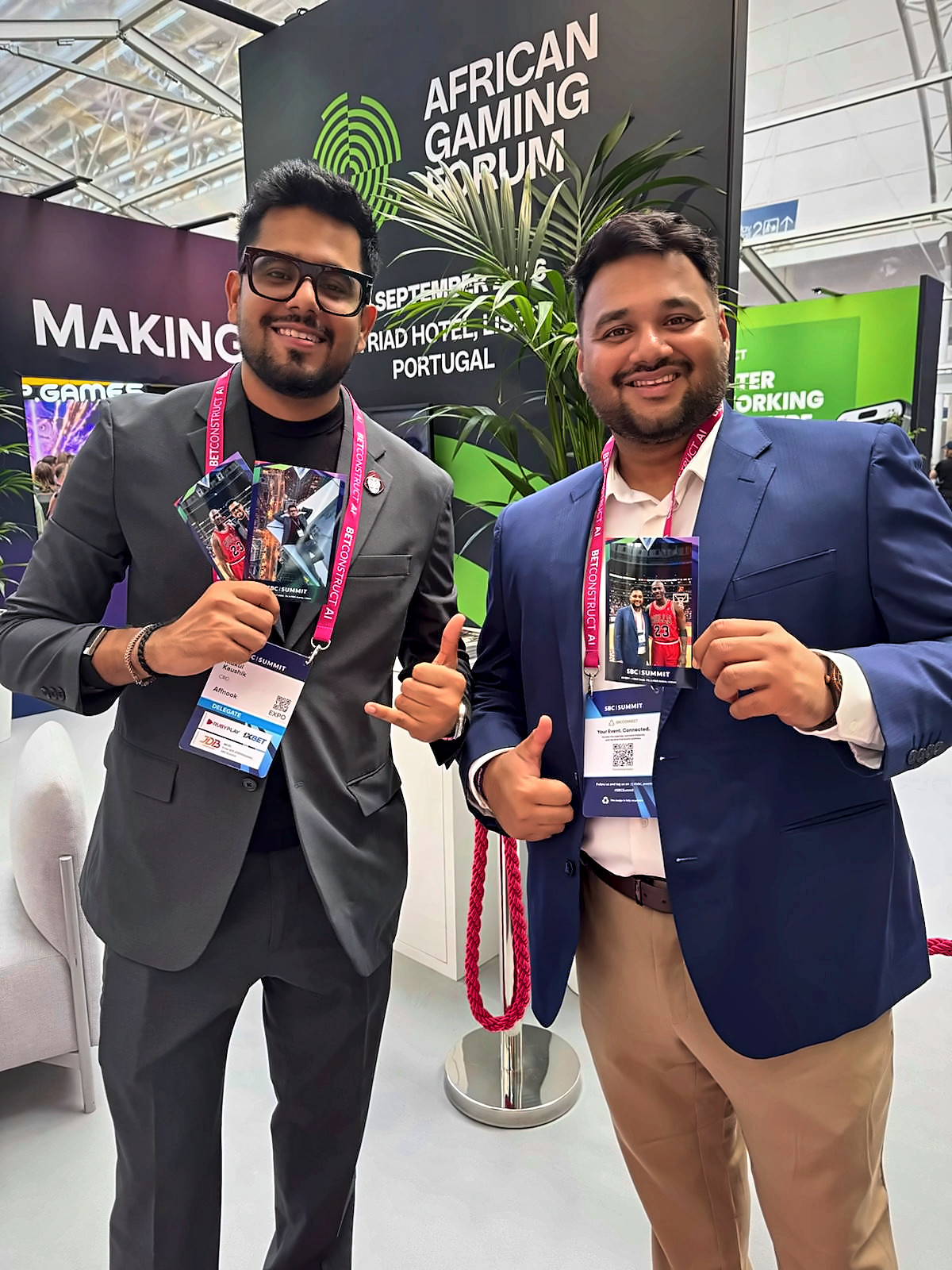 Two conference delegates holding AI photo prints