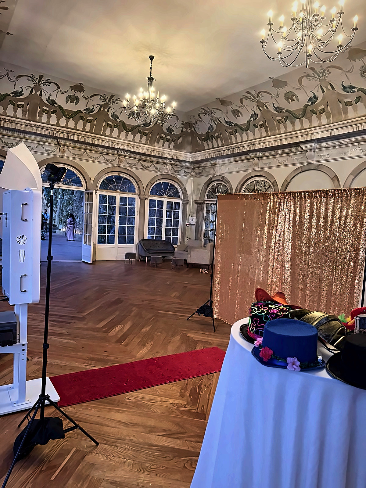 Photo booth with gold sequin backdrop in a palace ballroom