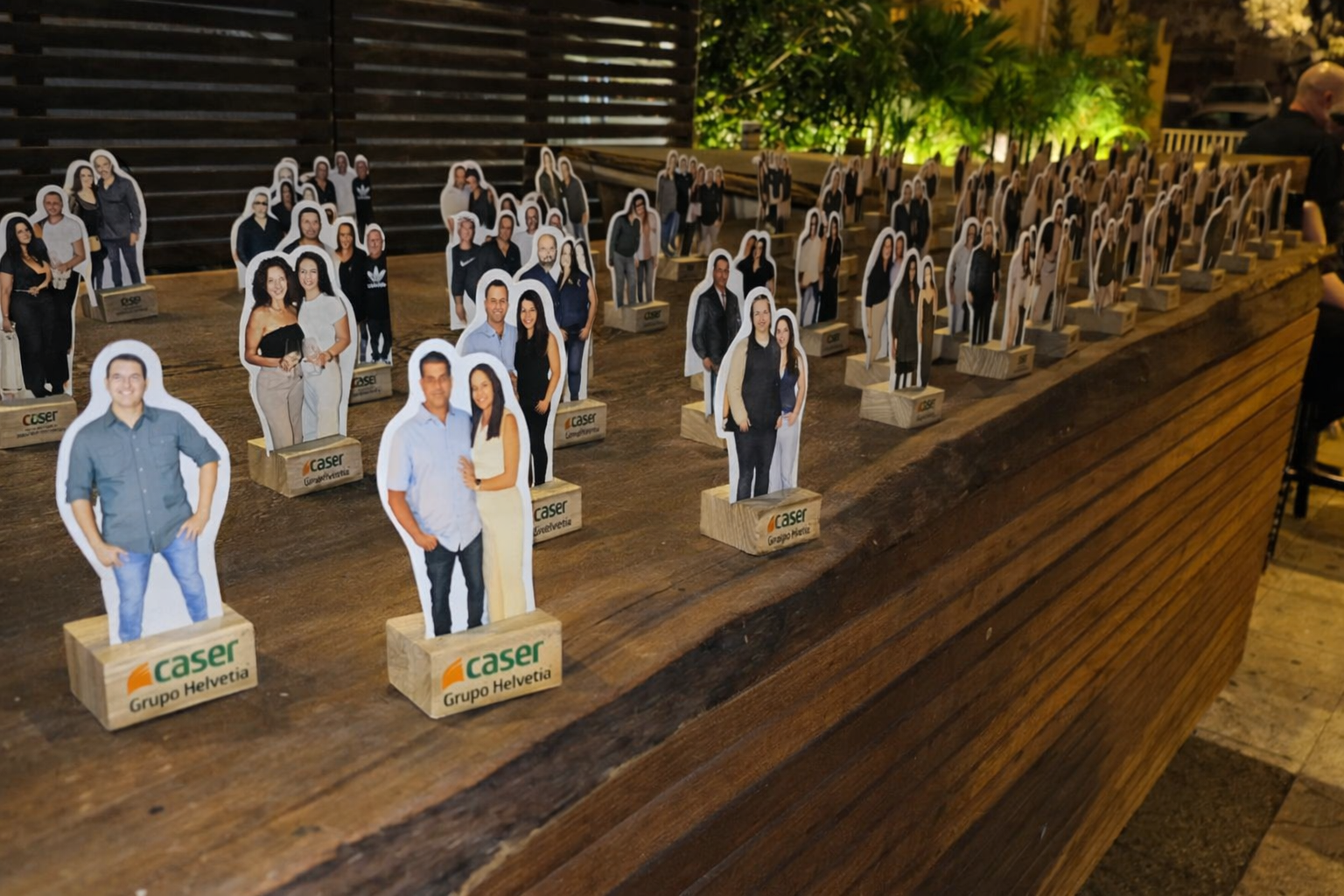 Many photo cutout standees lined up on a bar