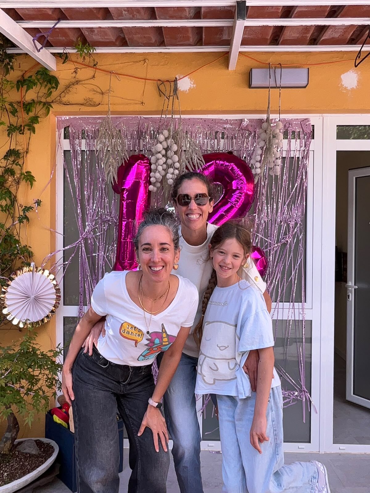 Guests posing in front of a balloon backdrop at a birthday party